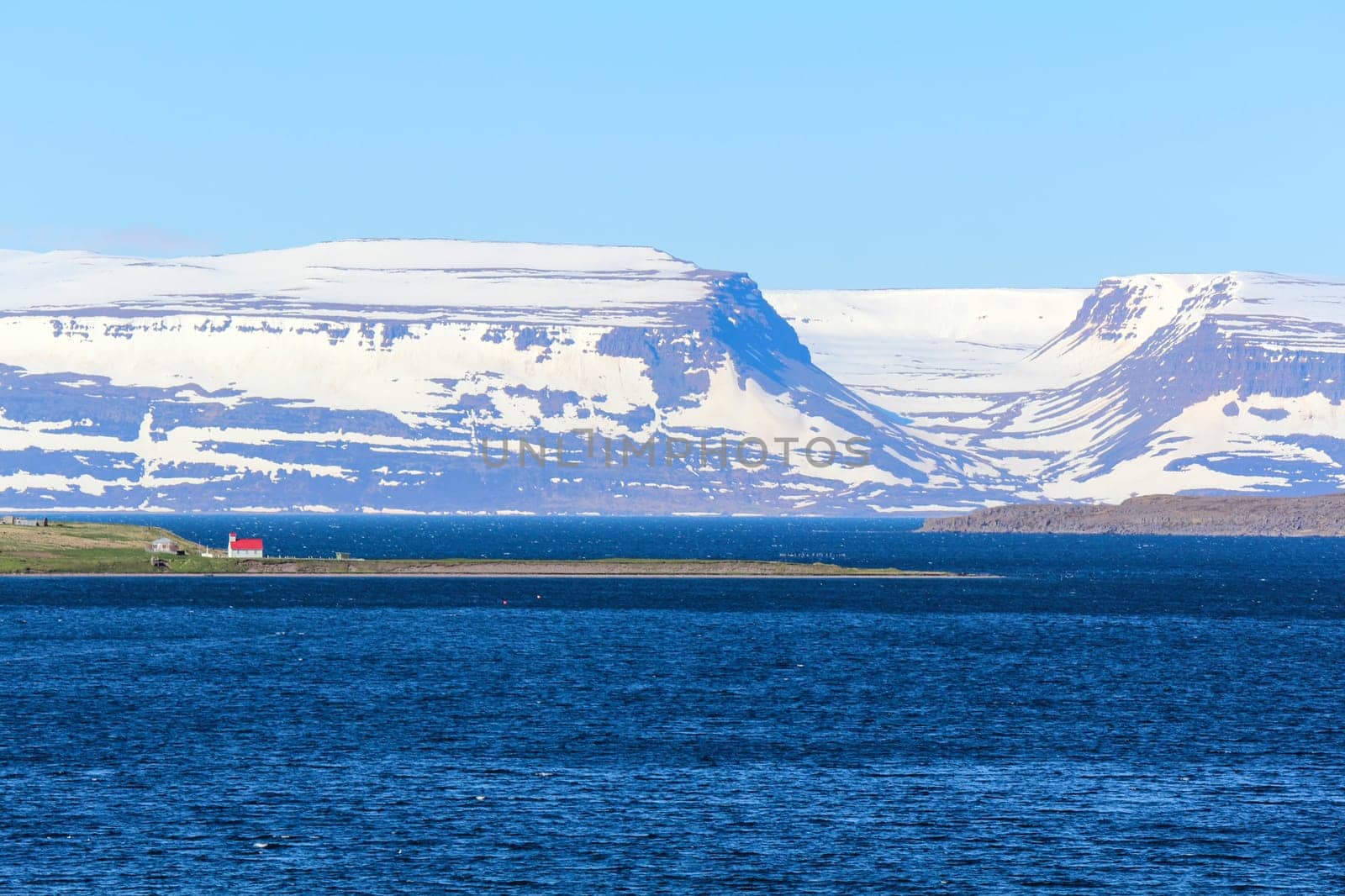 View to the next coast, church with red roof in between, Iceland