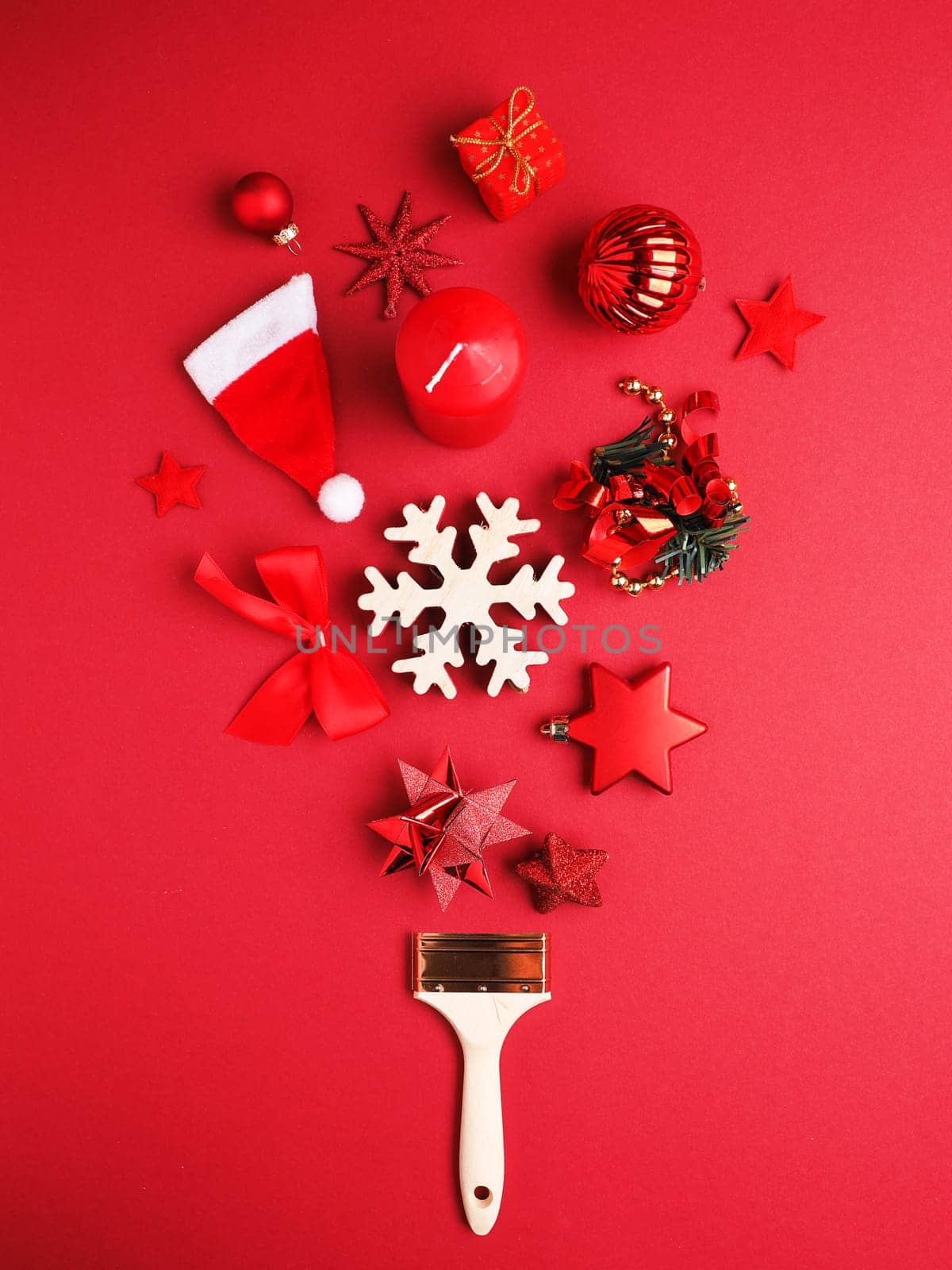 Paintbrush with Christmas decoration on a red background, greetings card or holiday background