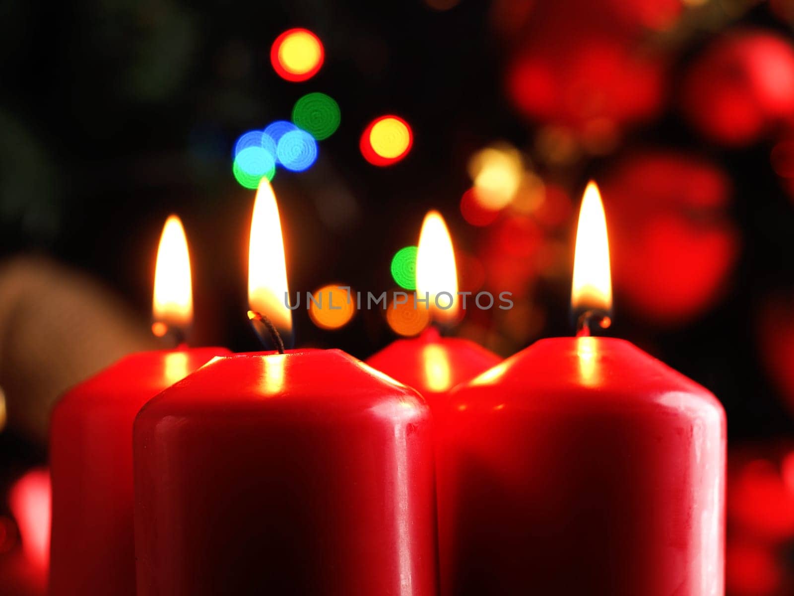 Third Advent candle burning, red Advent candles with decoration in a dark room, space for text or image
