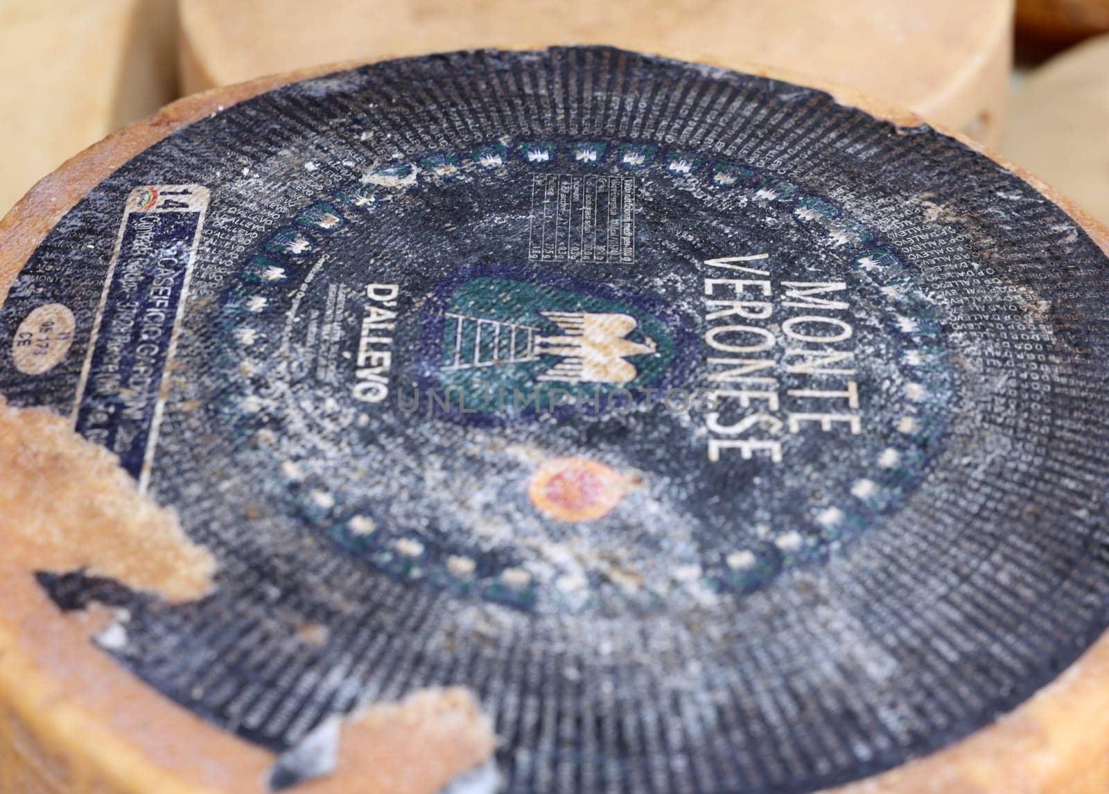 Cremona, Italy - September 7, 2022: Whole wheels of Monte Veronese cheese sold at a street stall during the farmers market in Cremona, Lombardy, Italy