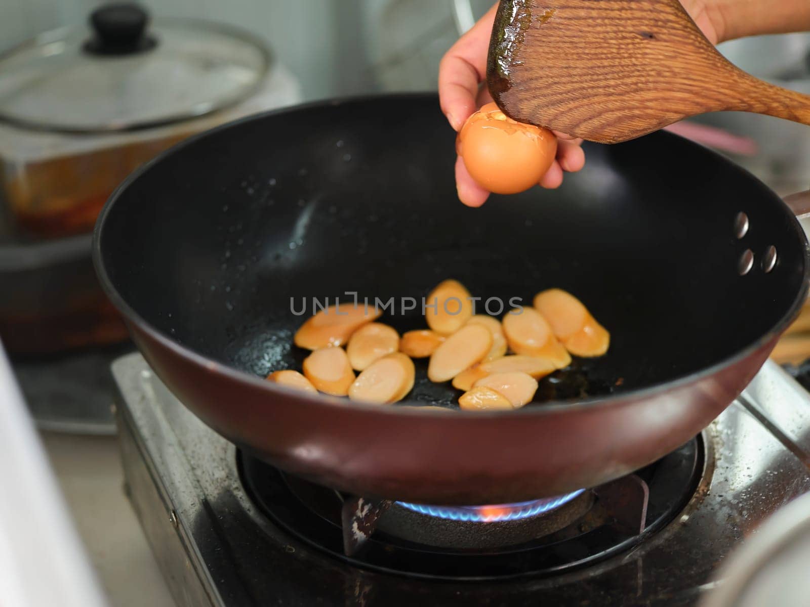 Cooking of sausage fried rice and crack an egg  with mixed vegetable .