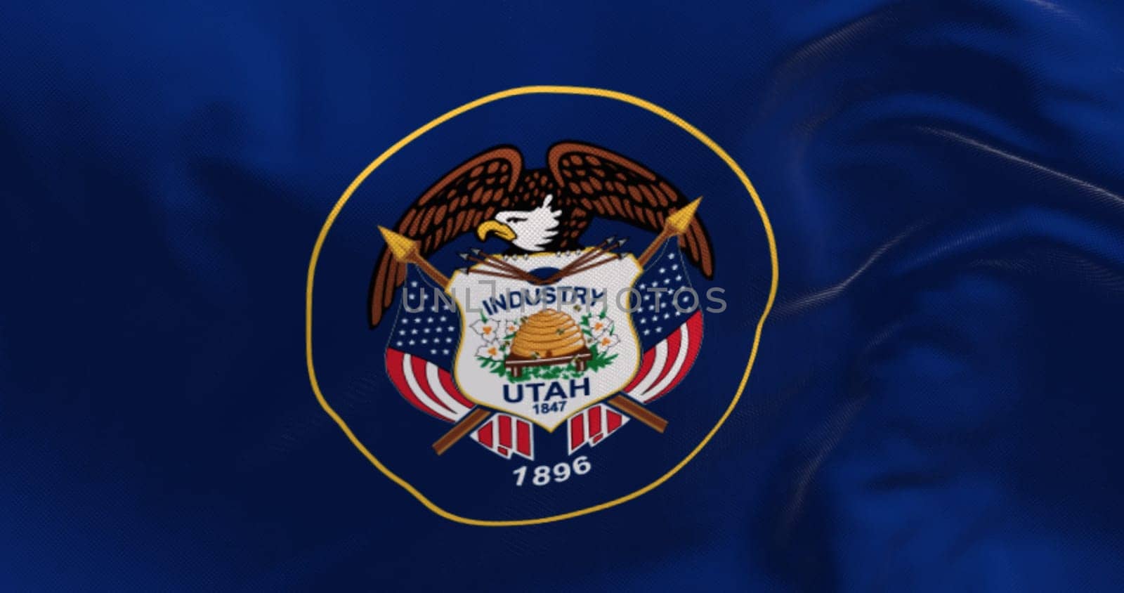 Close-up of Utah state flag waving. State seal encircled in a golden circle on a background of dark navy blue. 3d illustration render. Fluttering fabric background