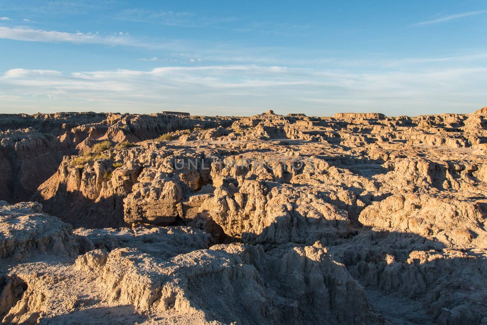 Jagged sandstone mountains illuminated from the sun in Badlands National Park, USA