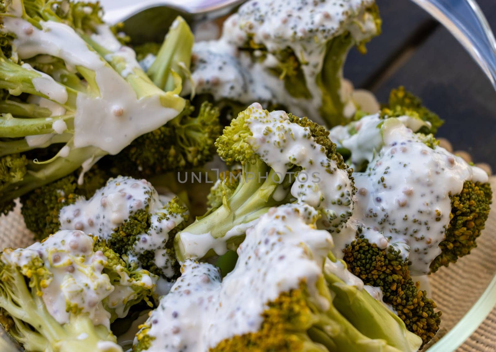 Healthy diet. Steamed broccoli topped with yogurt sauce