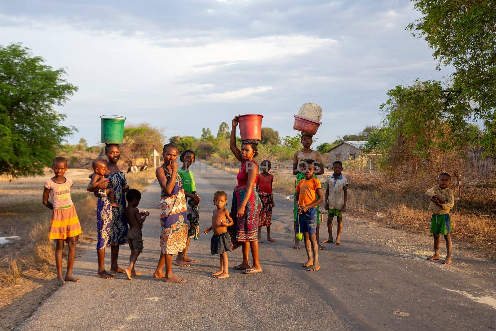Amkilizato-Mahabo, Madagascar - November 4th 2022: Group of woman with babies in hand and container on head, a common sight in this rural Madagascar village