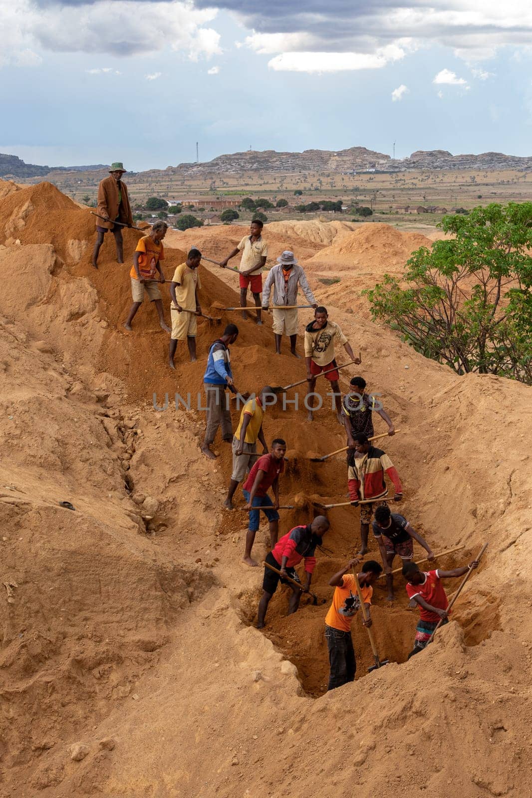 Ilakaka, Madagascar - November 24th 2022 - Working in tandem, miners united their effort, shoveling earth and meticulously seeking out sapphire gems, synchronized effort reminiscent of linked chains.