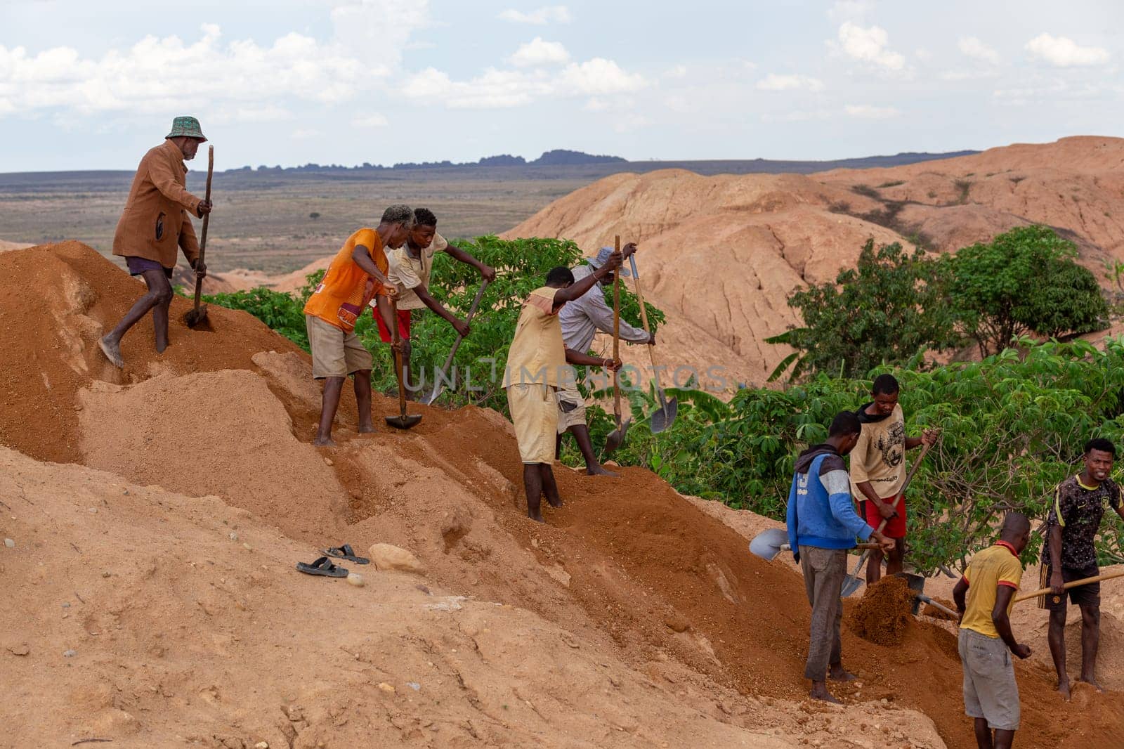 Ilakaka, Madagascar - November 24th 2022 - Working in tandem, miners united their effort, shoveling earth and meticulously seeking out sapphire gems, synchronized effort reminiscent of linked chains.
