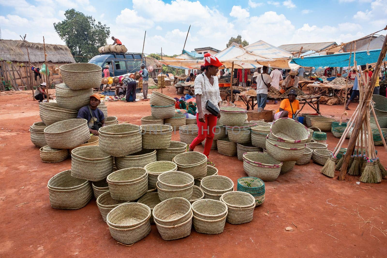 Mandoto, Madagascar - November 9th, 2022: Sale of wicker basket in street market in Mandoto city, with vendors and ordinary people shopping and socializing.