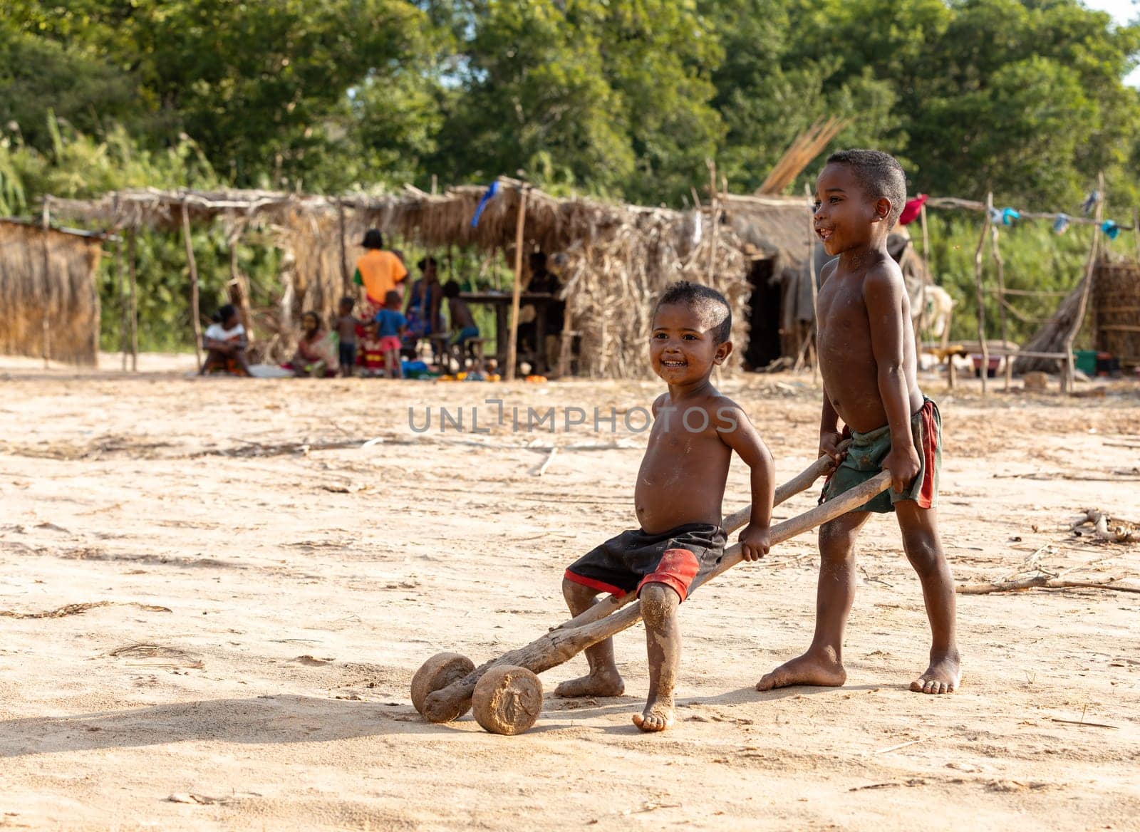 Ferry port Bekopaka, Madagascar - NOVEMBER 4 2022: Boys have fun with a simple toy on wheels at the ferry port in Bekopaka.