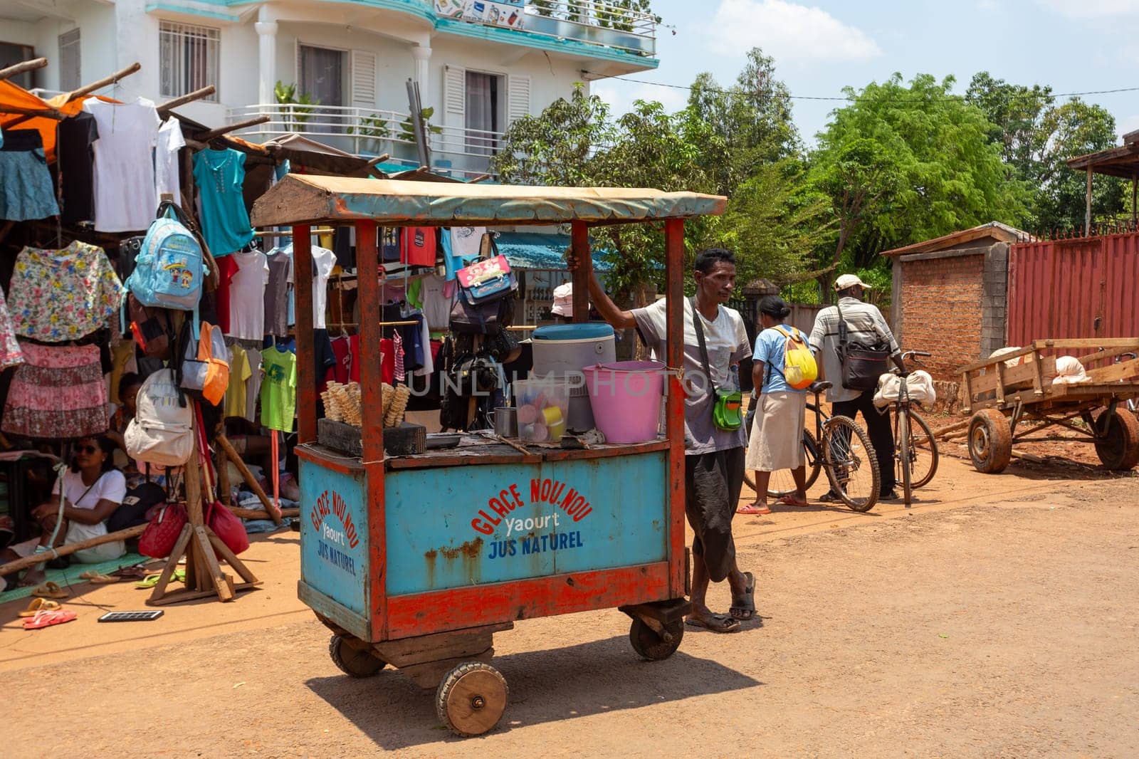 Mandoto, Madagascar - November 9th, 2022: Street in Mandoto city, with vendors and ordinary people shopping and socializing. Man sell ice cram.