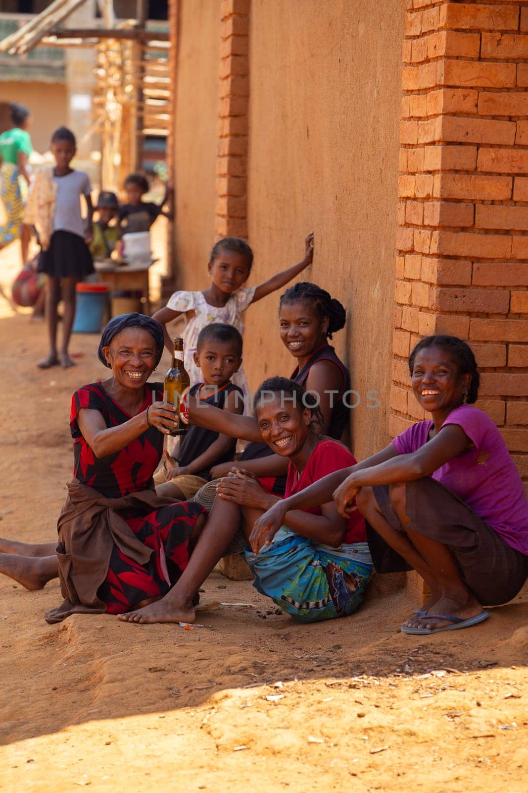 Vohitsaoka, Madagascar - November 17, 2022: Local woman drinking beer on the street at noon.