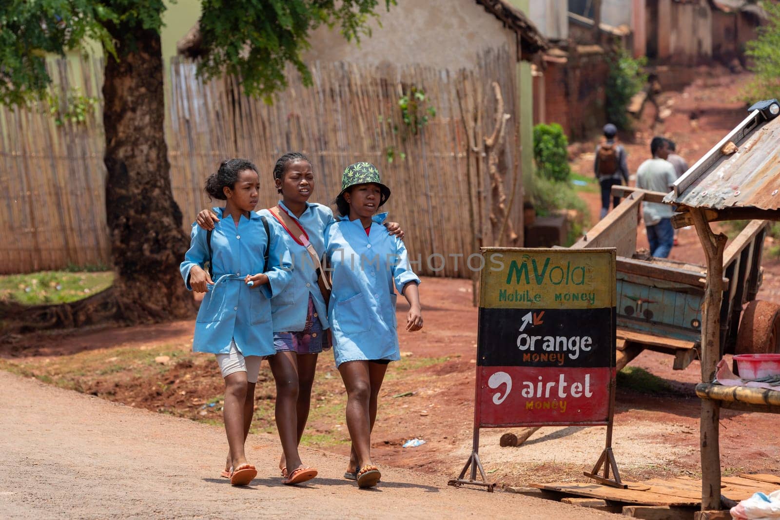 MANDOTO, MADAGASCAR - NOVEMBER 9 2022: The three Malagasy schoolgirls in blue uniforms are a symbol of hope for the future of Madagascar. They are bright, ambitious and determined to change the world.