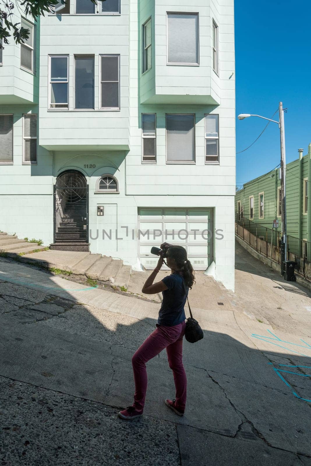 A female tourist taking a picture at steep Lombard street in San Francisco, USA