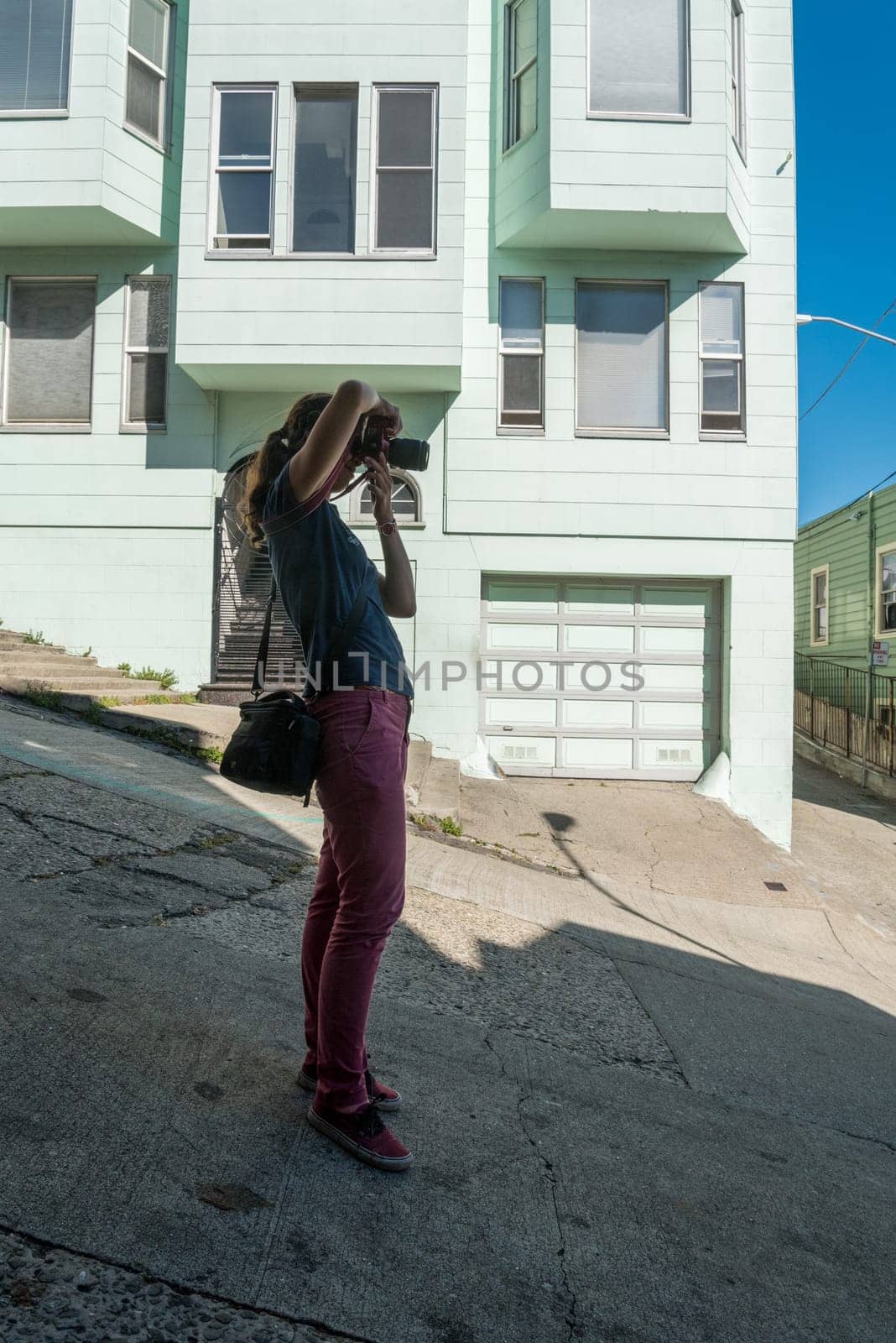 A female tourist taking a picture at steep Lombard street in San Francisco, USA