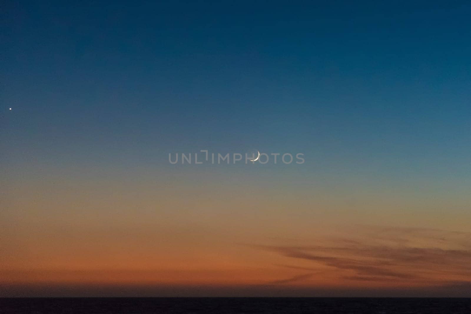 Crescent moon scenic above the last sunlight of the day
