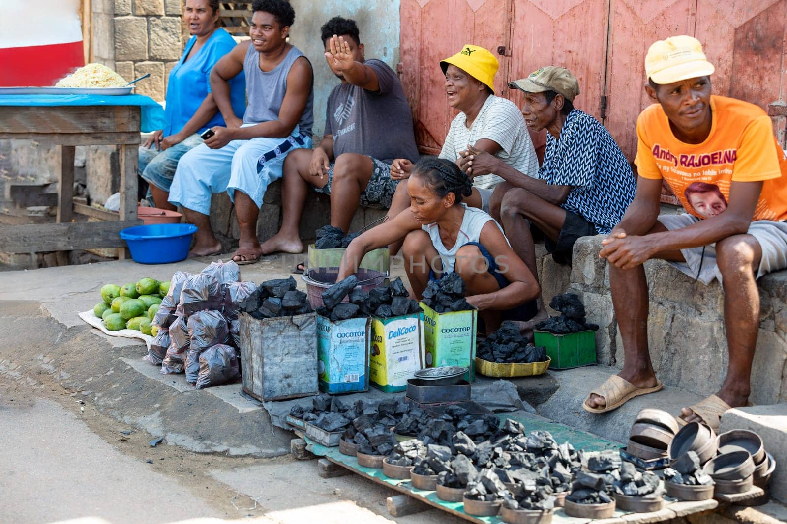 Miandrivazo, Madagascar - November 2, 2022: Street market in Miandrivazo, woman selling charcoal. Wood charcoal is mainly used for cooking in Madagascar.