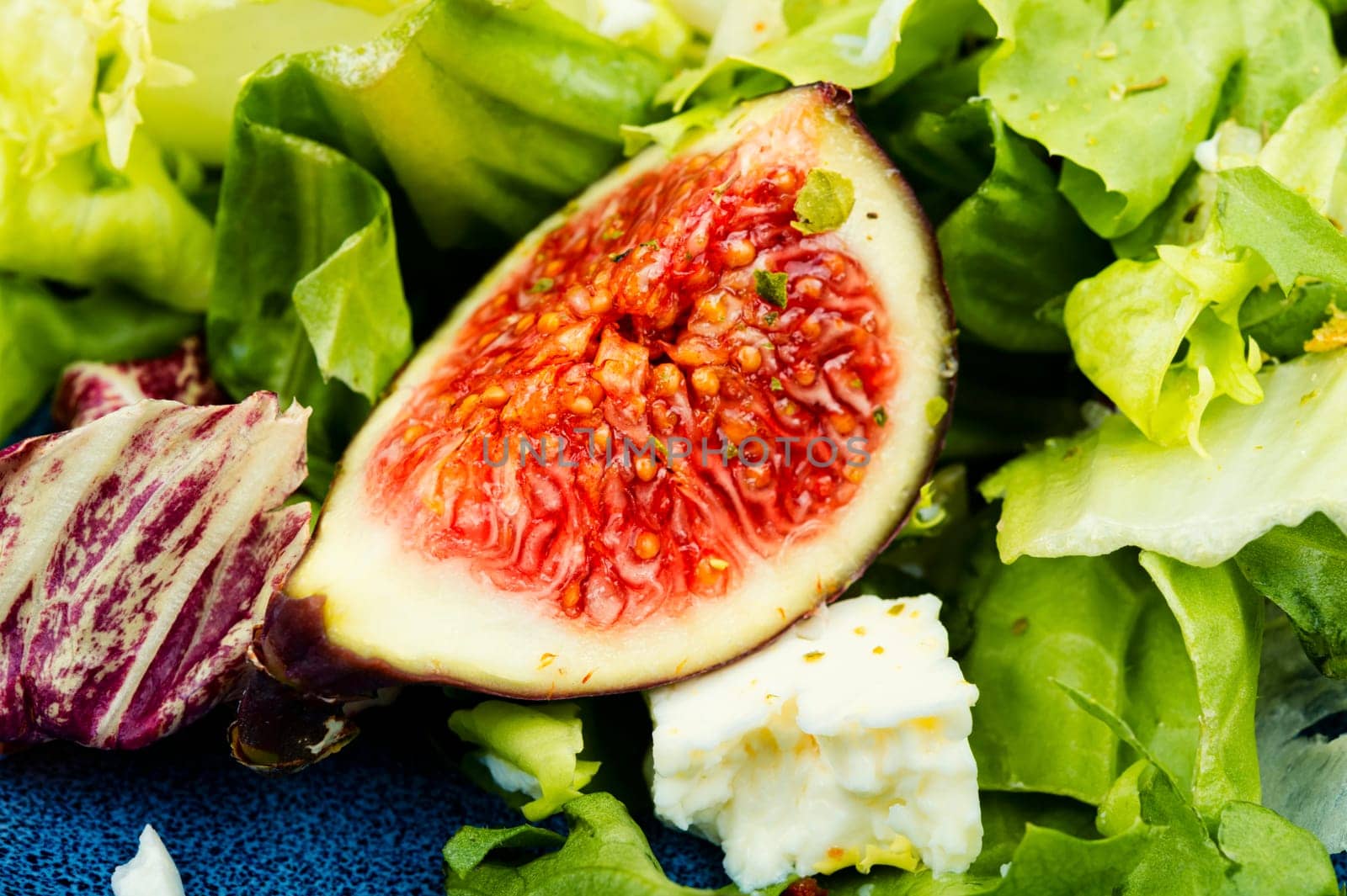 Appetizer homemade salad with figs, herbs and cheese.