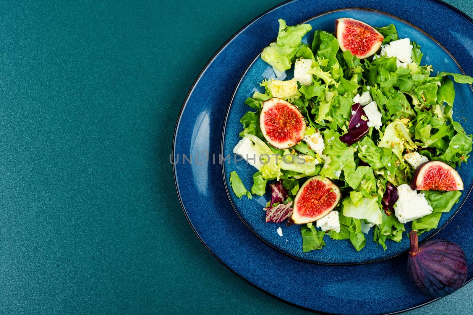 Appetizer homemade salad with figs, herbs and cheese.