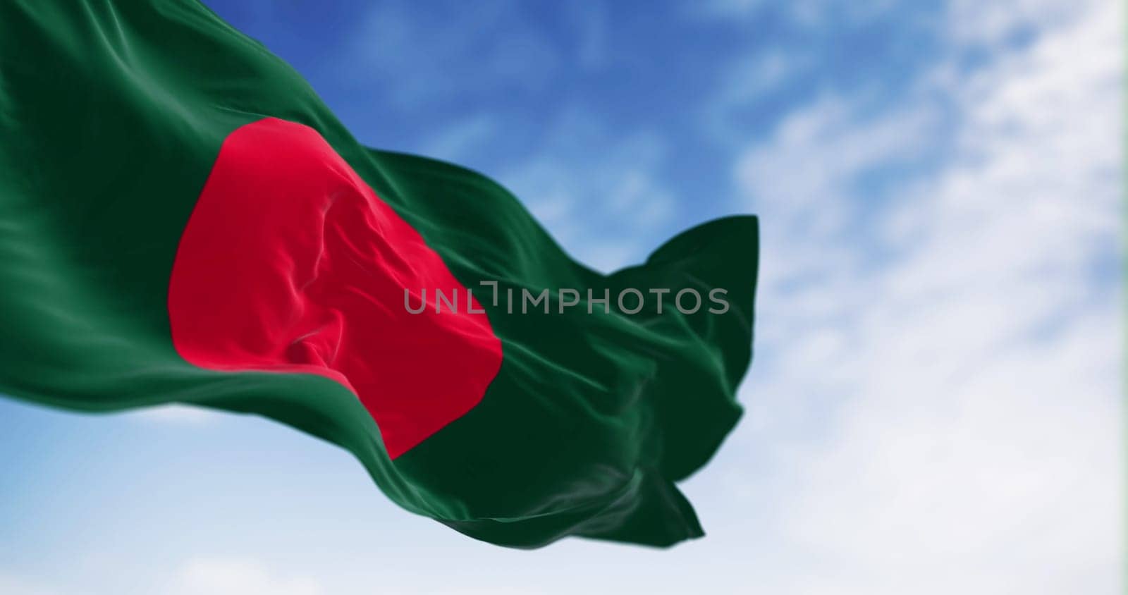 National flag of Bangladesh waving in the wind on a clear day. Dark green banner with a red disc or sun on top. 3d illustration render. Fluttering fabric