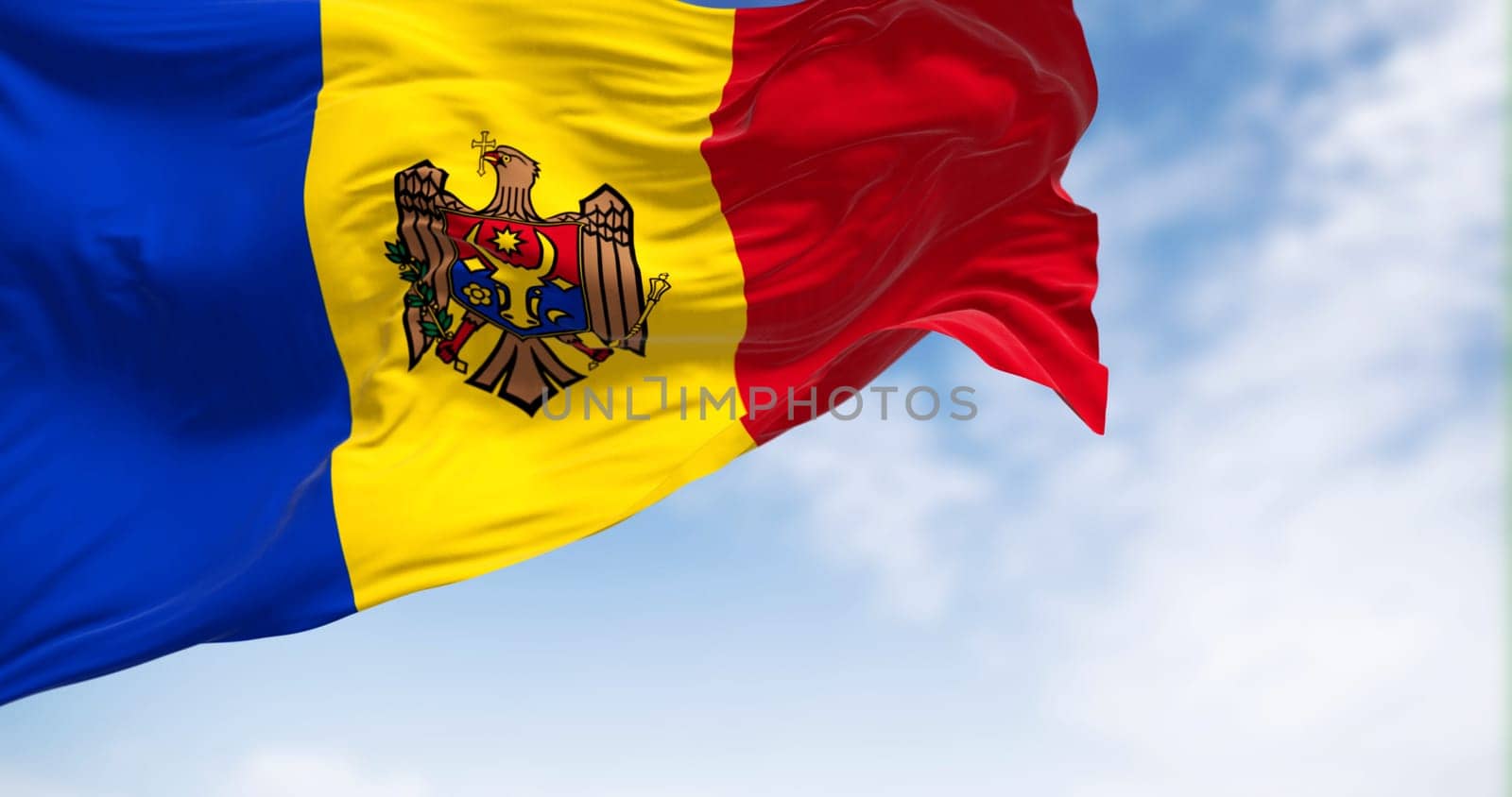 Moldova national flag waving in the wind on a clear day. vertical tricolor of blue, yellow, and red with the national coat of arms in the center. 3d illustration render. Fluttering fabric