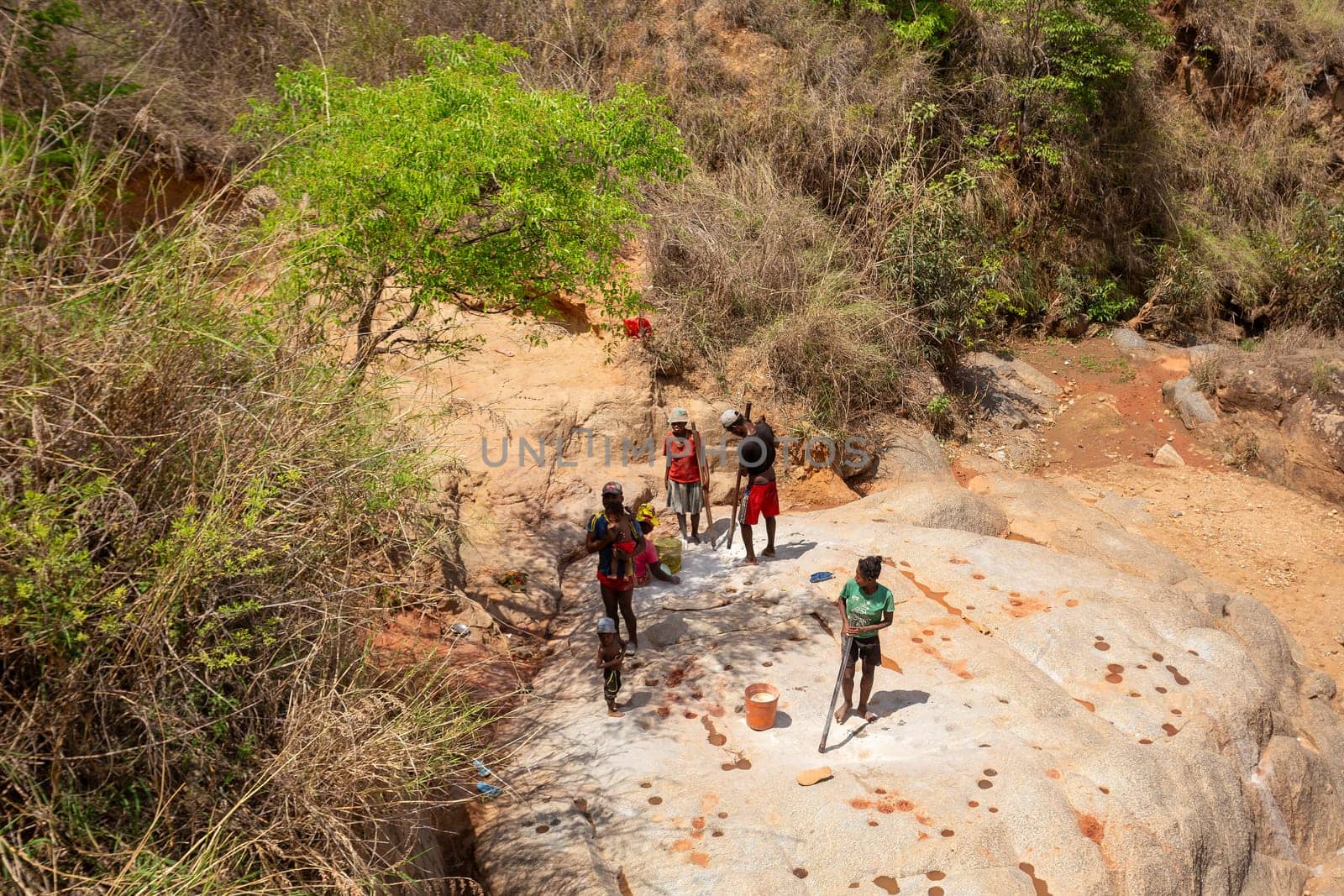 Dabalava, Madagascar - November 1, 2022: Local people mine for gems and pan for gold in a river. If they're lucky, they'll find a little gold flake