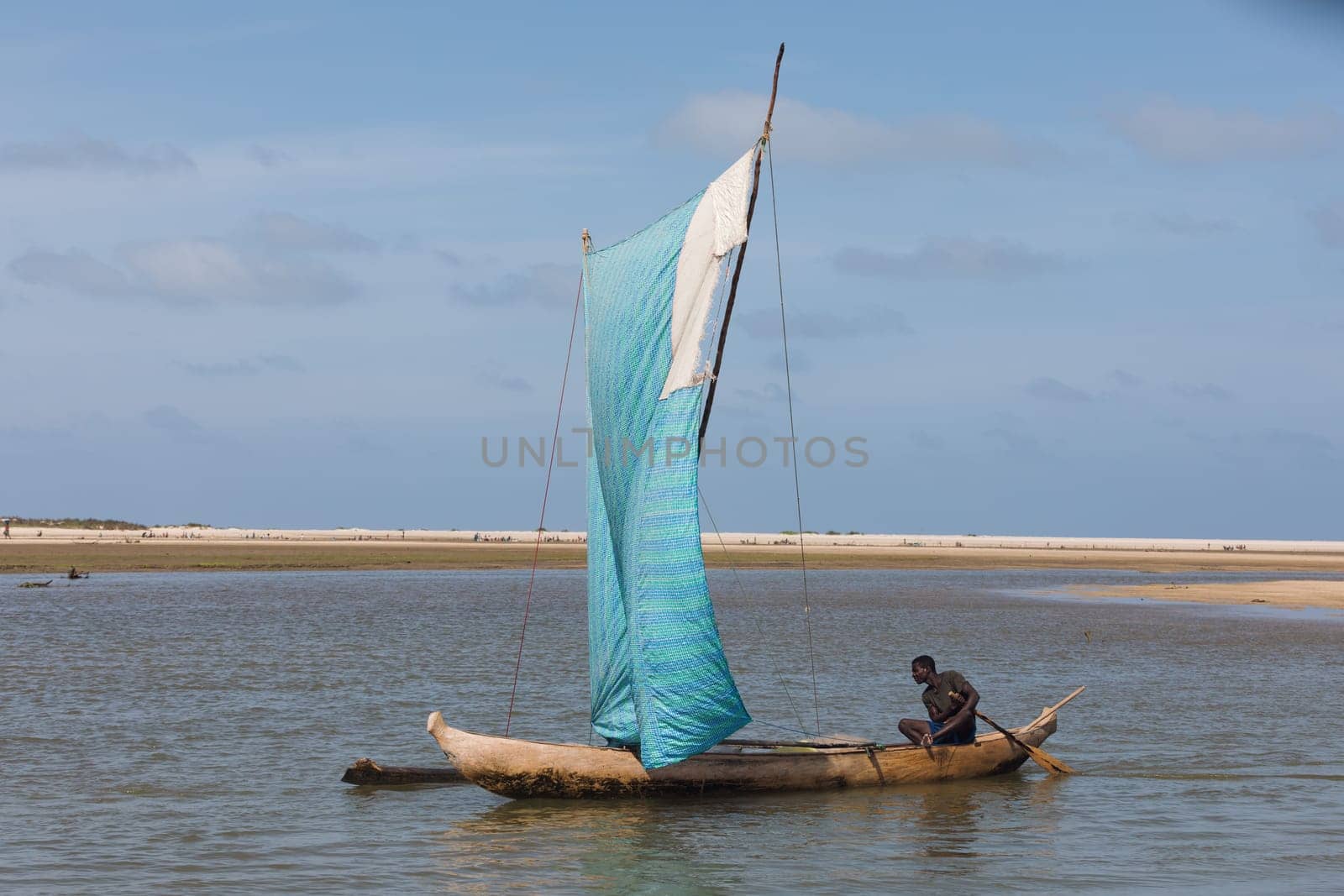 Morondava, Madagascar - November 3rd 2022: A fisherman sails back from the sea to the river on a sailboat in Morondava