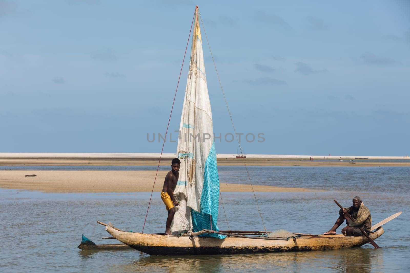 Morondava, Madagascar - November 3rd 2022: A fisherman sails back from the sea to the river on a sailboat in Morondava