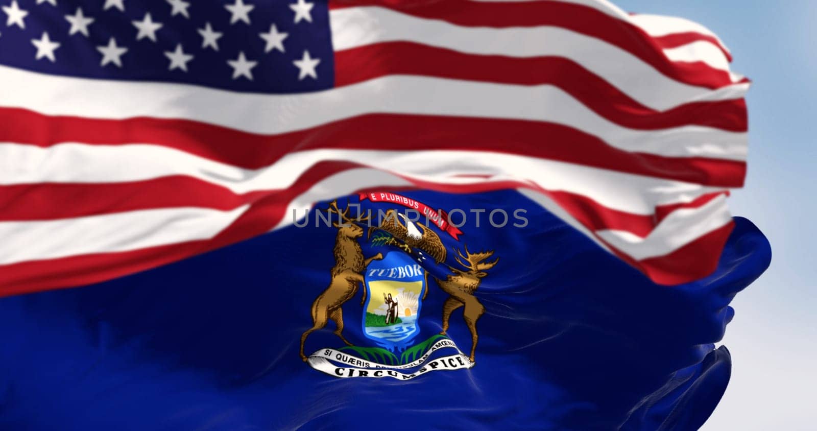 Flags of Michigan and the United States waving in the wind on a clear day. Patriotism and identity concept. 3d illustration render. Fluttering fabric. Selective focus.