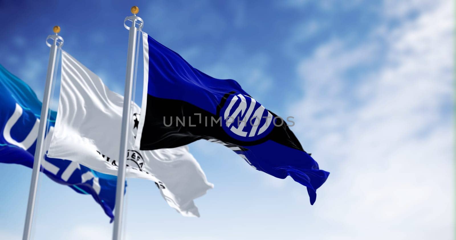MIlan, IT, Sept. 10 2023: Flags of UEFA, UEFA CHampions League and Inter FC waving in the wind on a clear day. Illustrative editorial 3d illustration render. Fluttering fabric