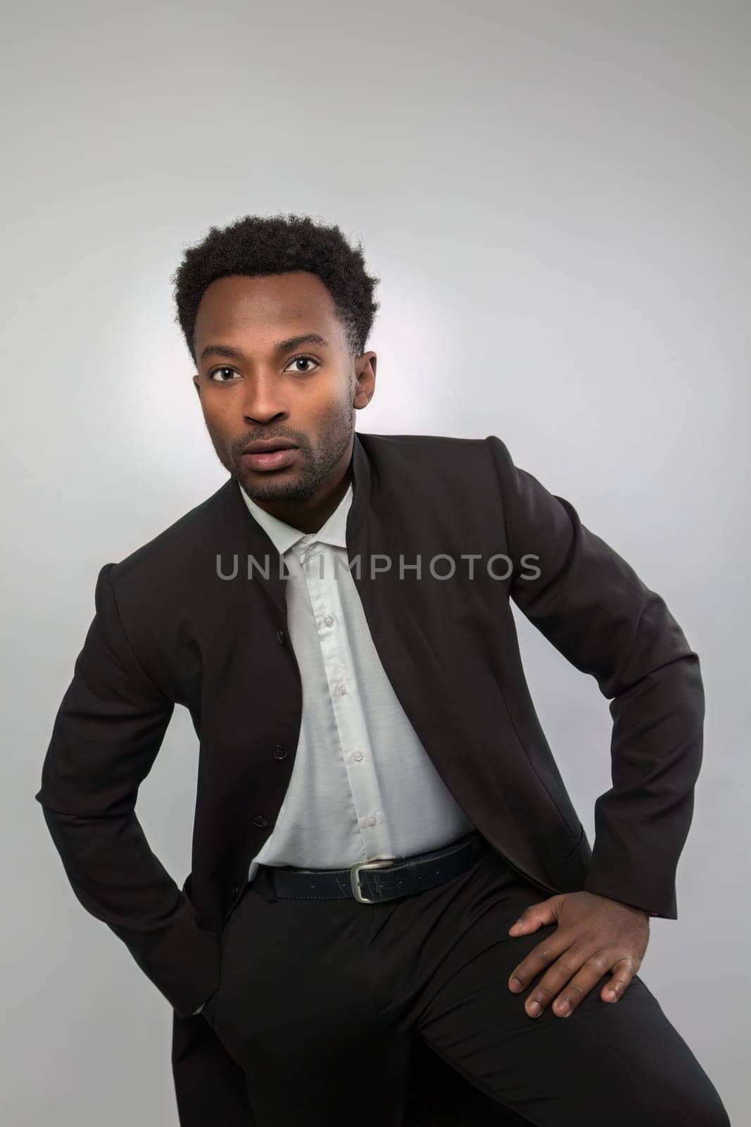 twenty year old man suit style on white background studio portrait serious confident businessman hand on thigh
