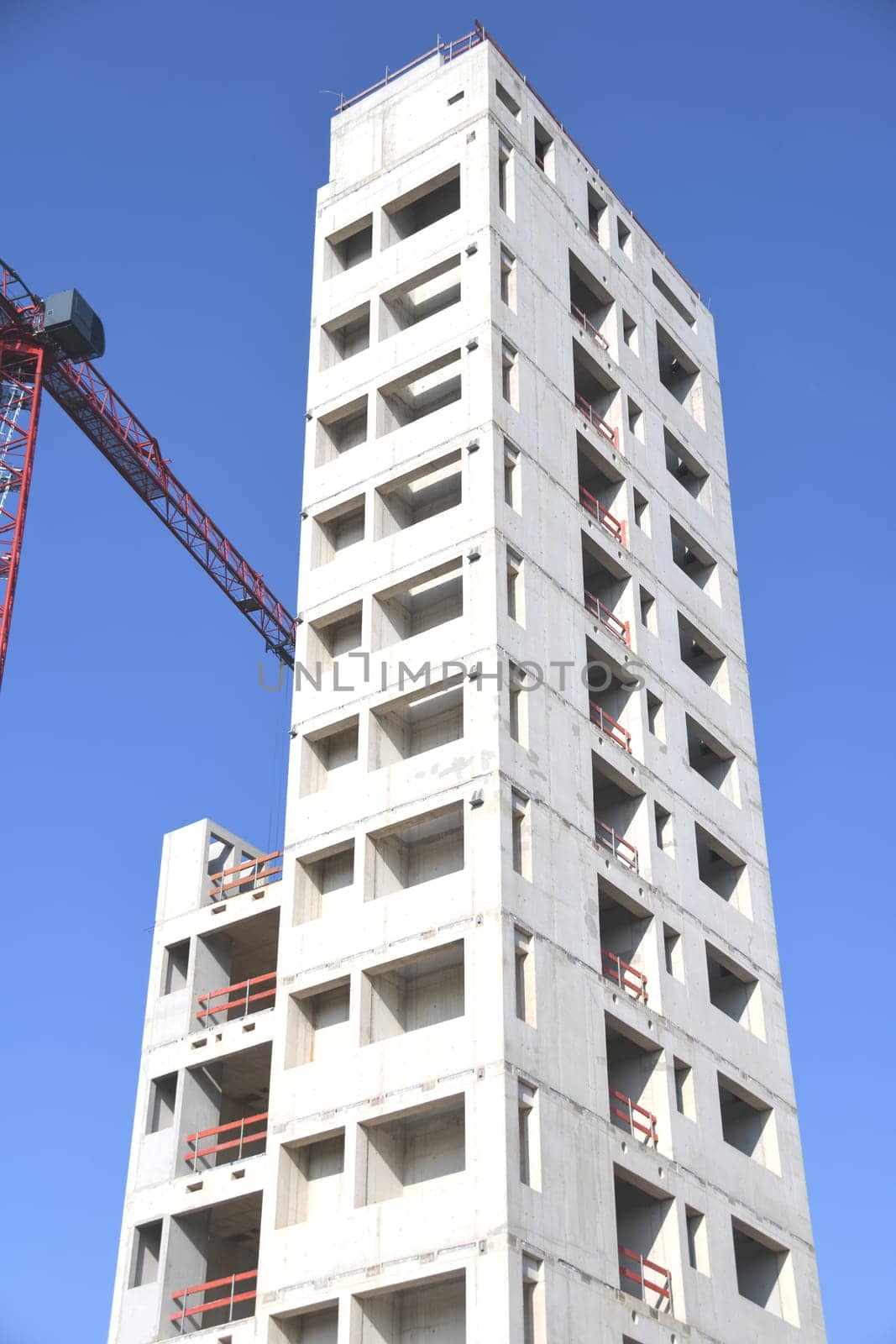 A high-rise building is being built. For fire protection,the stairwell of the office building was made of concrete. The construction crane transports the building materials to the upper floors.