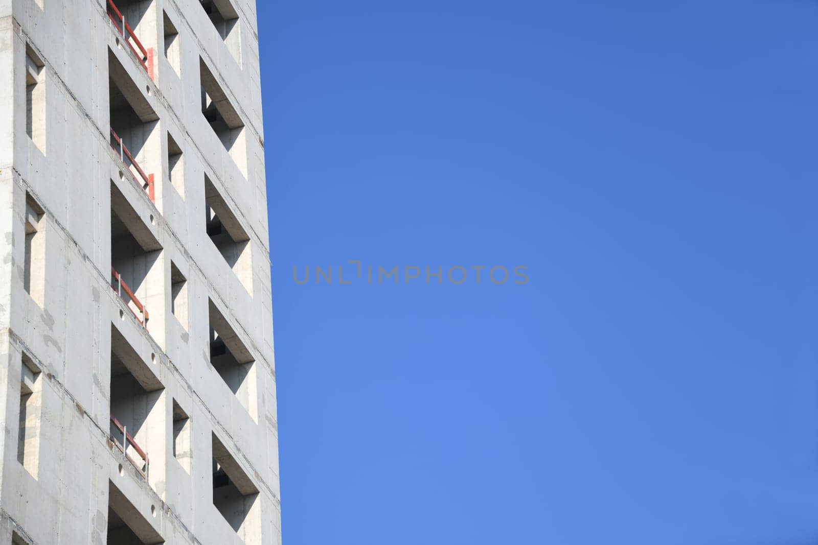 A high-rise building is being built. For fire protection,the stairwell of the office building was made of concrete. The sky as a background is blue.