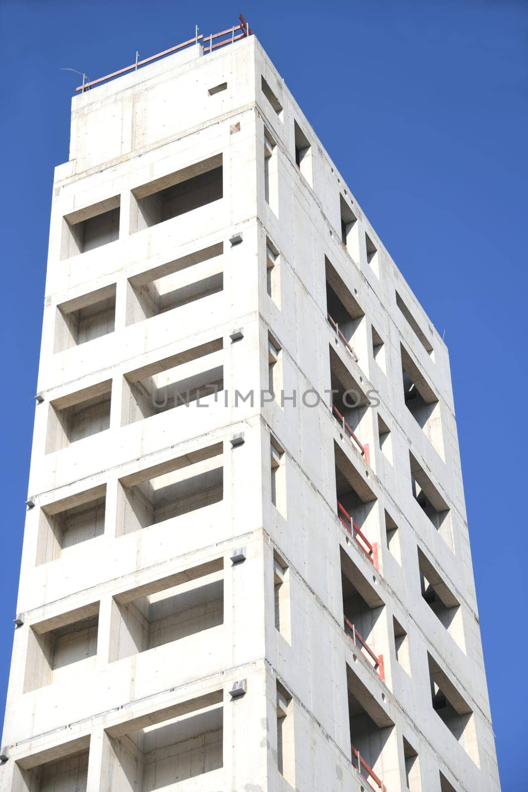 A high-rise building is being built. For fire protection,the stairwell of the office building was made of concrete. The sky is blue.
