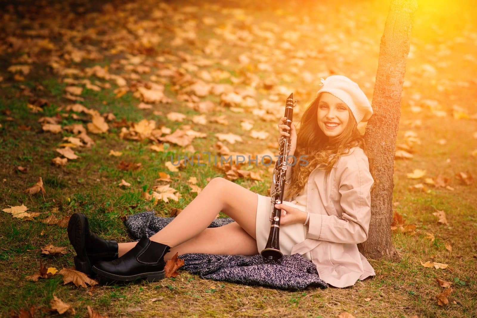 Young attractive girl with clarinet in fall park
