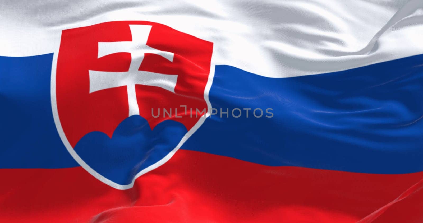 Close-up of Slovakia national flag waving in the wind on a clear day. White, blue, and red stripes. Coat of arms at the hoist. 3d illustration render. Rippled fabric