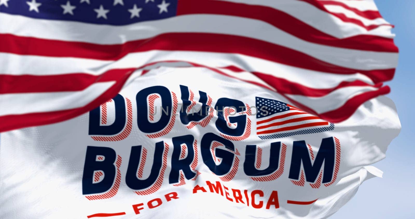 Arthut, US, June 2023: Flags of Doug Burgum election campaign and the national flag of the United States waving. 2024 US presidential elections. Illustrative editorial 3d illustration render