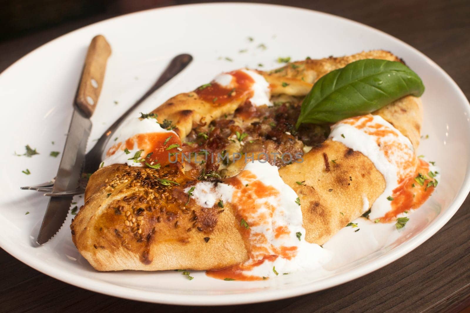 The pizza bread Italian food specialty as a meal is served on plate in restaurant.