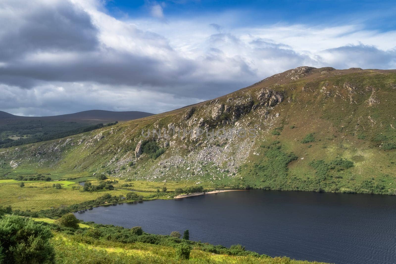 Beautiful panorama with lake, beach, forest, valley and rocky steep mountain. Lough Dan in Wicklow Mountains, Ireland