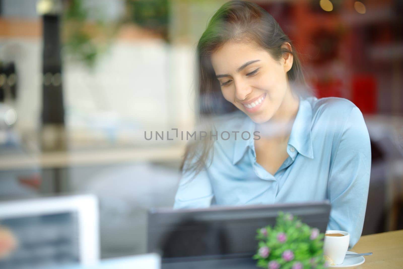 Happy elegant woman using tablet in a bar interior