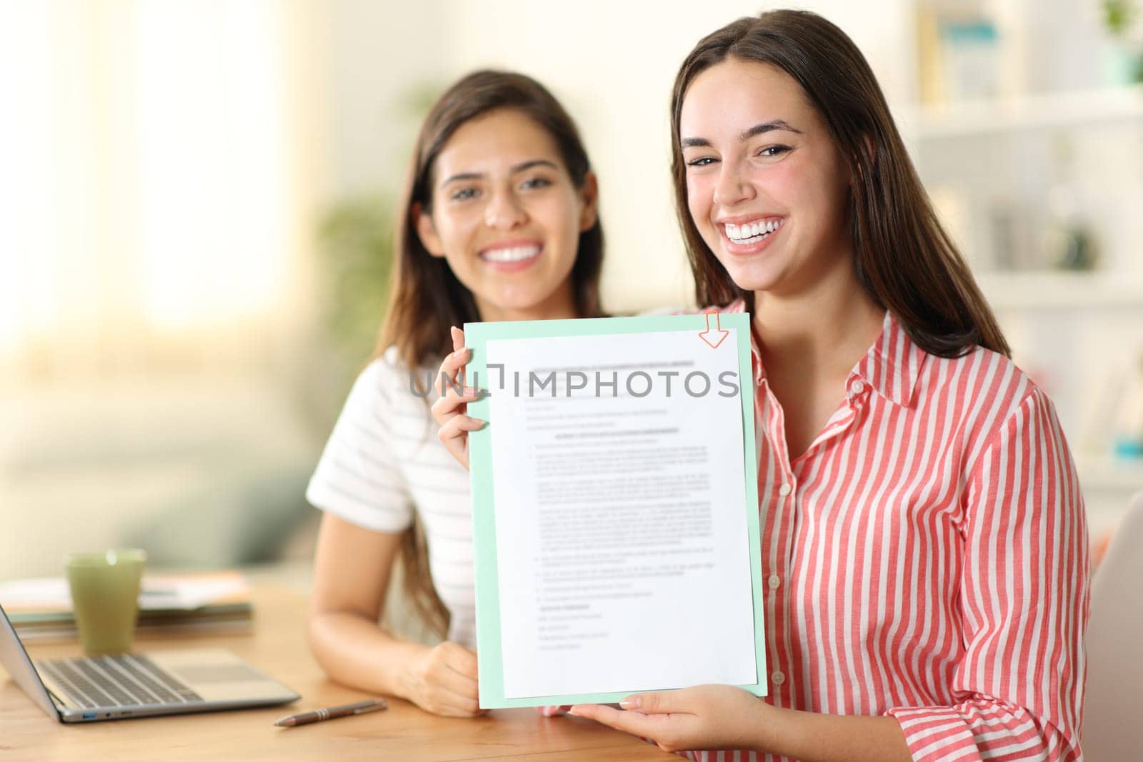 Happy women showing form at camera at home