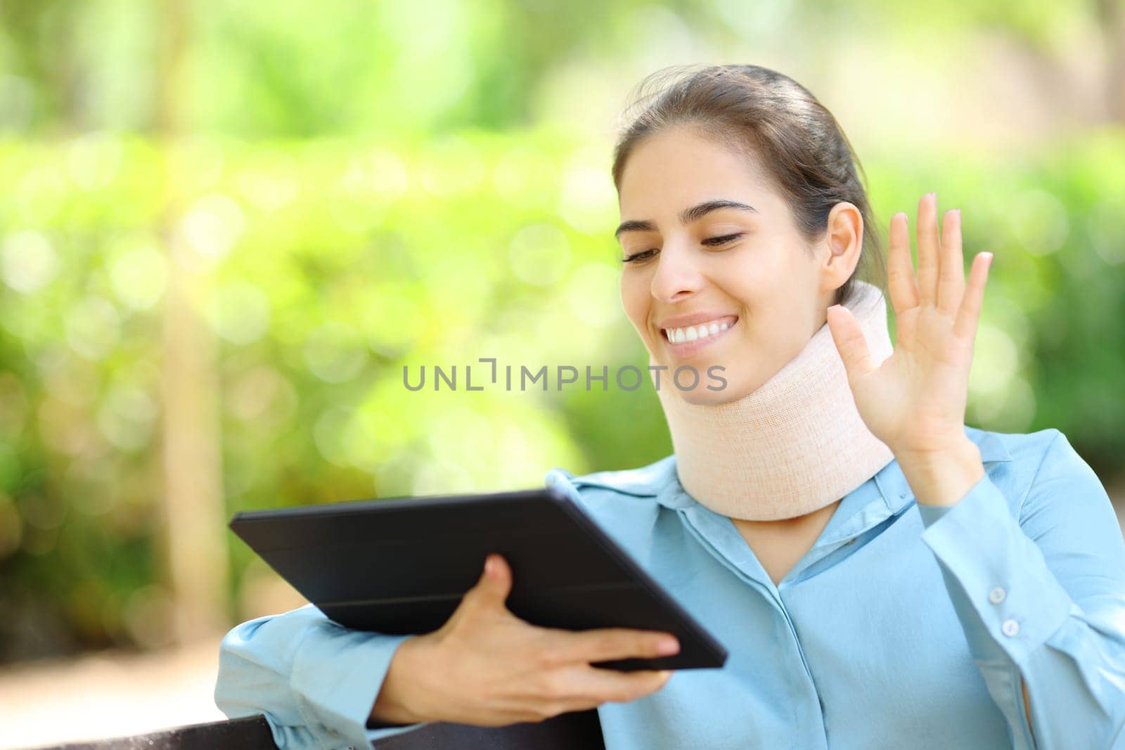 Convalescent businesswoman having videocall on tablet in a park