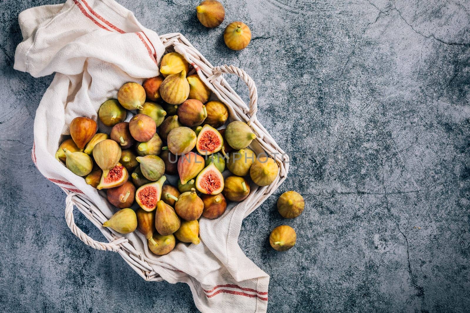 Freshly picked organic green figs in a basket on grey background
