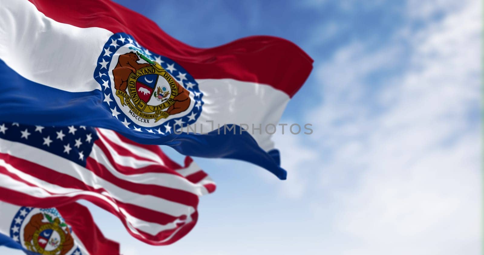 Close-up of Missouri state flags waving with the national american flag on a clear day. 3d illustration render. Rippled fabric. Selective focus