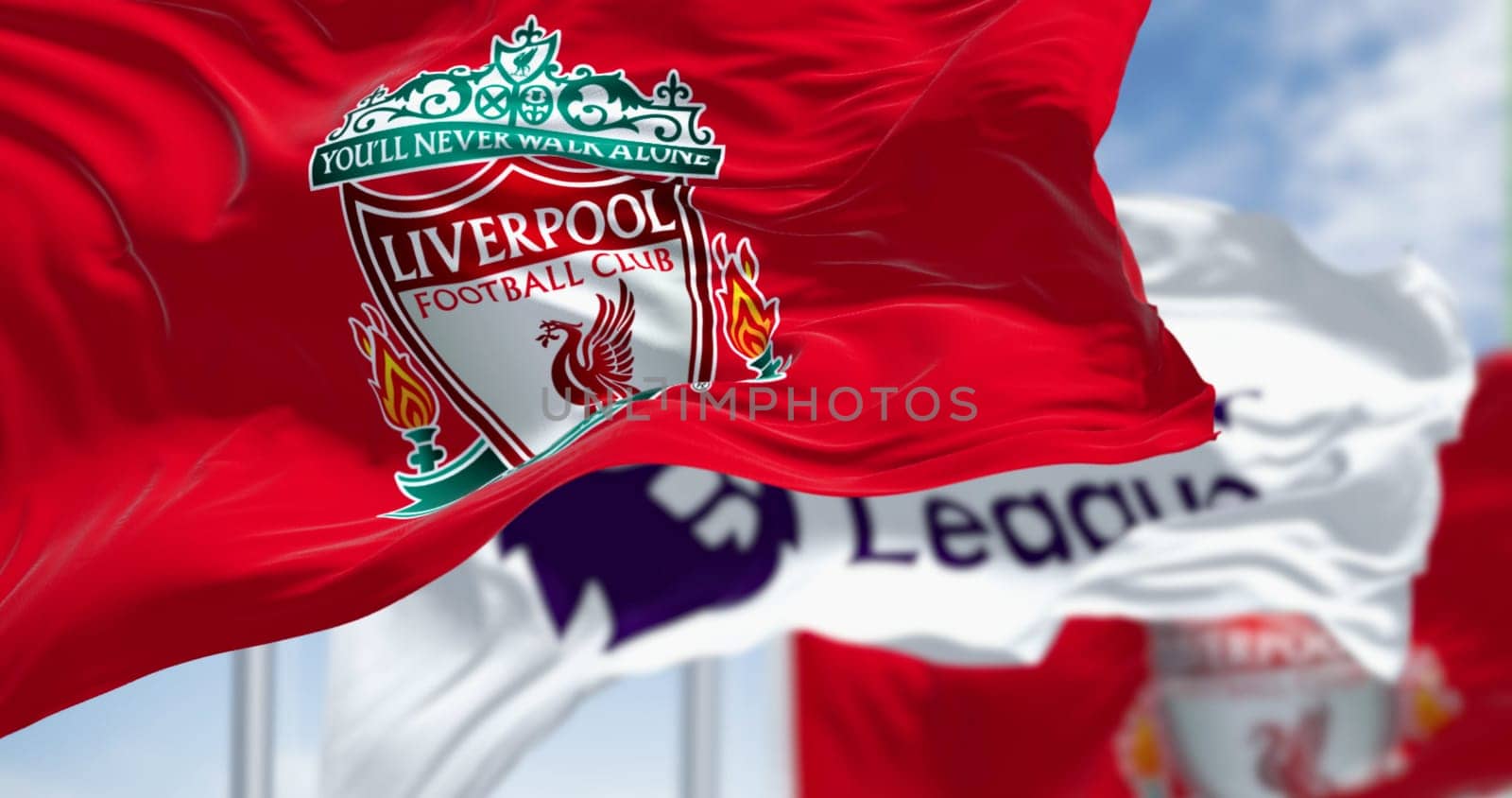 Liverpool, UK  seot. 14 2023: Liverpool Football Club and Premier League flags waving together on a clear day. Illustrative editorial 3d illustration render. Fluttering fabric. Selective focus