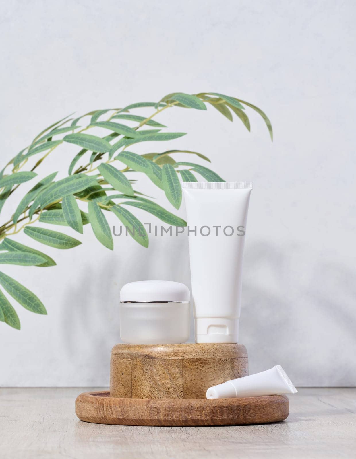 White plastic tubes and jar for cosmetic products on a white background, advertising and branding of products