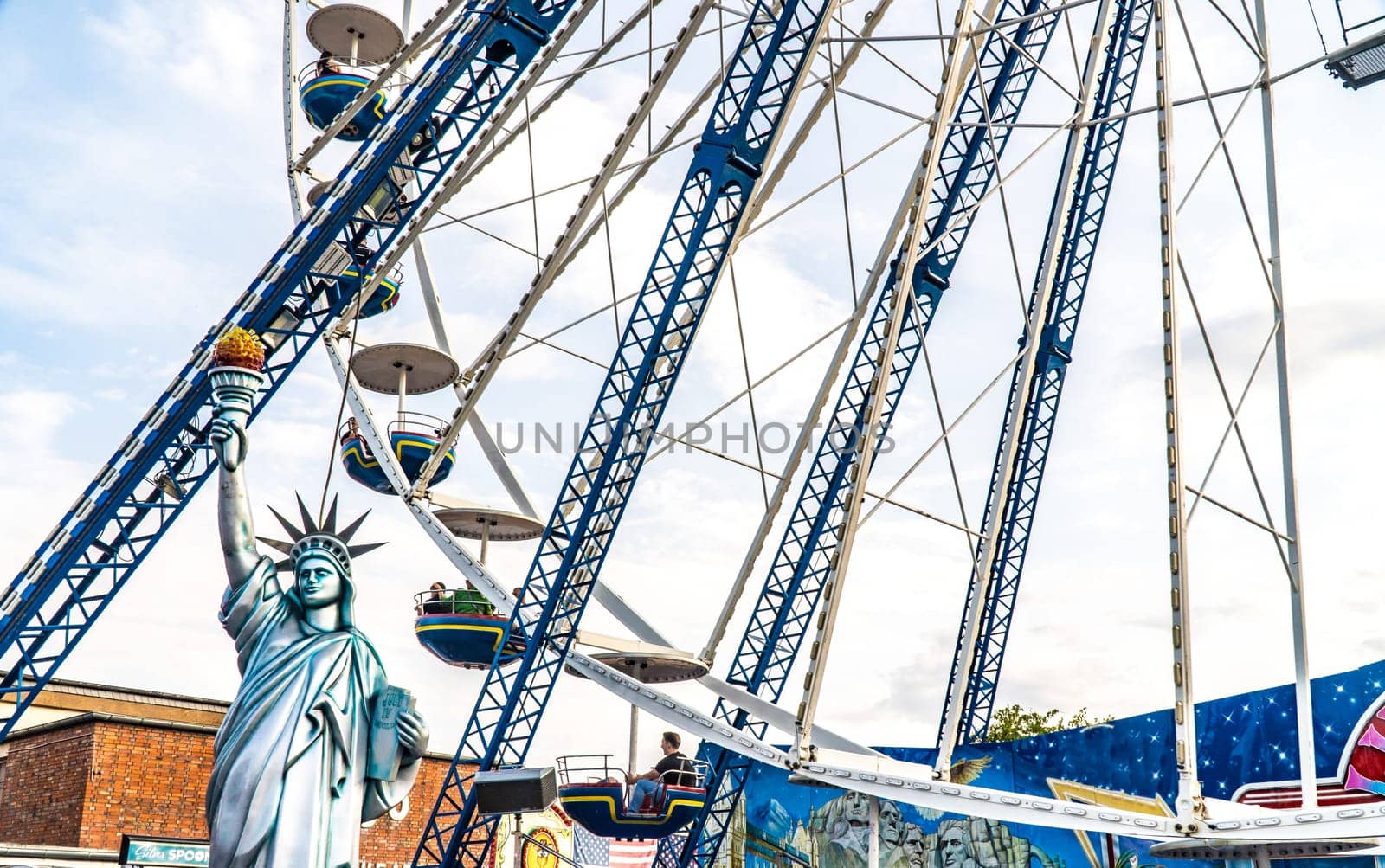 Ferris wheel with statue of liberty at the fairground on a beautiful summer day in germany.