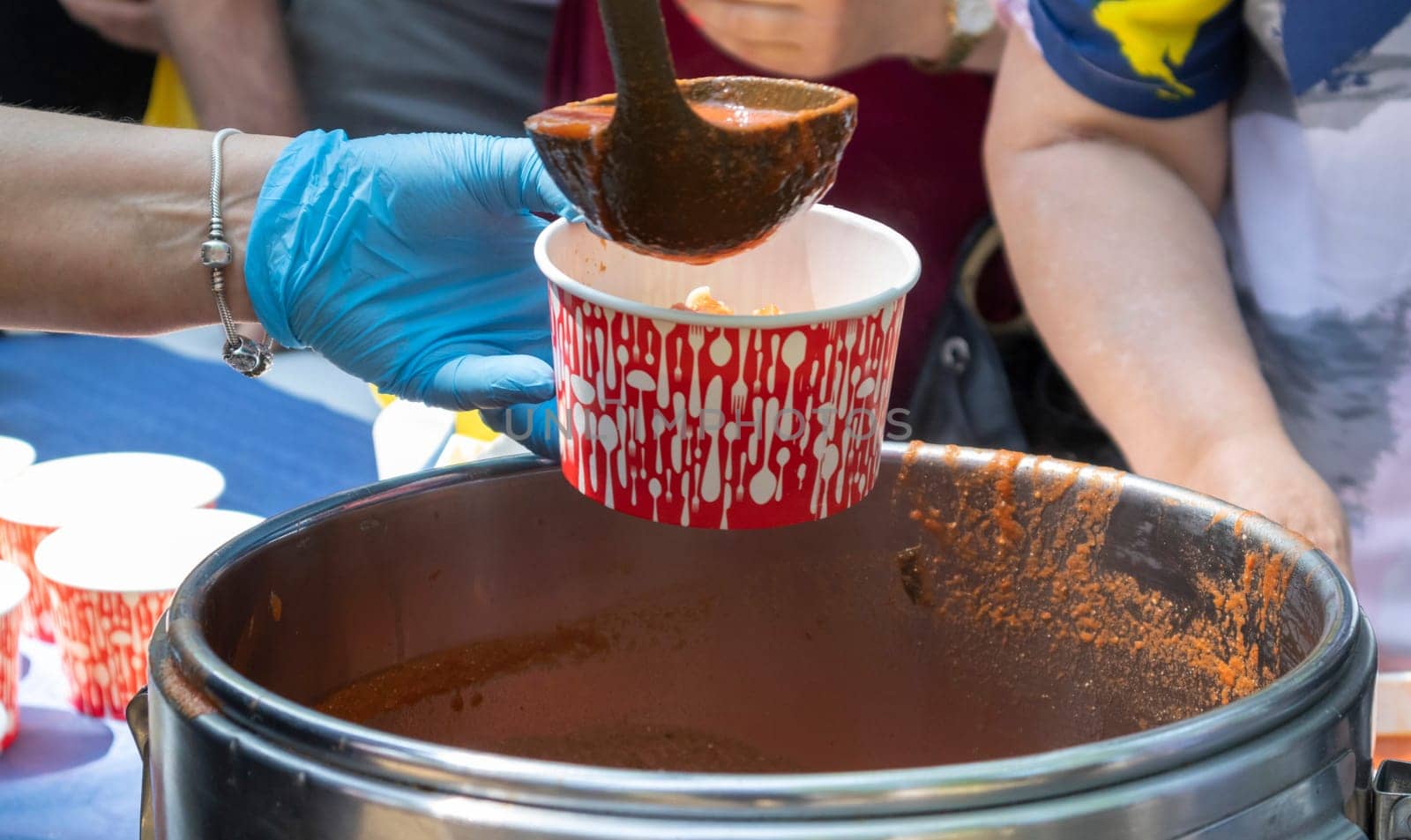 Tomato soup with pasta is a Polish dish. Zupa pomidorowa. Hot soup made from grated tomatoes. People and tourists walk, eat and buy food at the street food festival. Ukraine, Kyiv - August 17, 2023