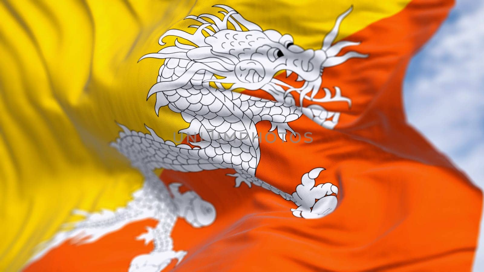 Close-up of Bhutan national flag waving in the wind. Yellow upper triangle and an orange lower triangle, featuring a white dragon holding jewels in the center. 3d illustration render. Selective focus