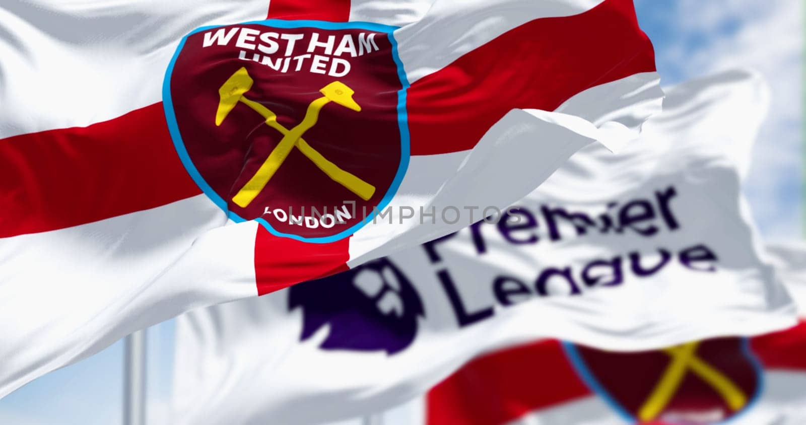 London, UK, July 3 2023: West Ham United FC and Premier League flags waving on a clear day. English football club based in London. Illustrative editorial 3d illustration render. Selective focus