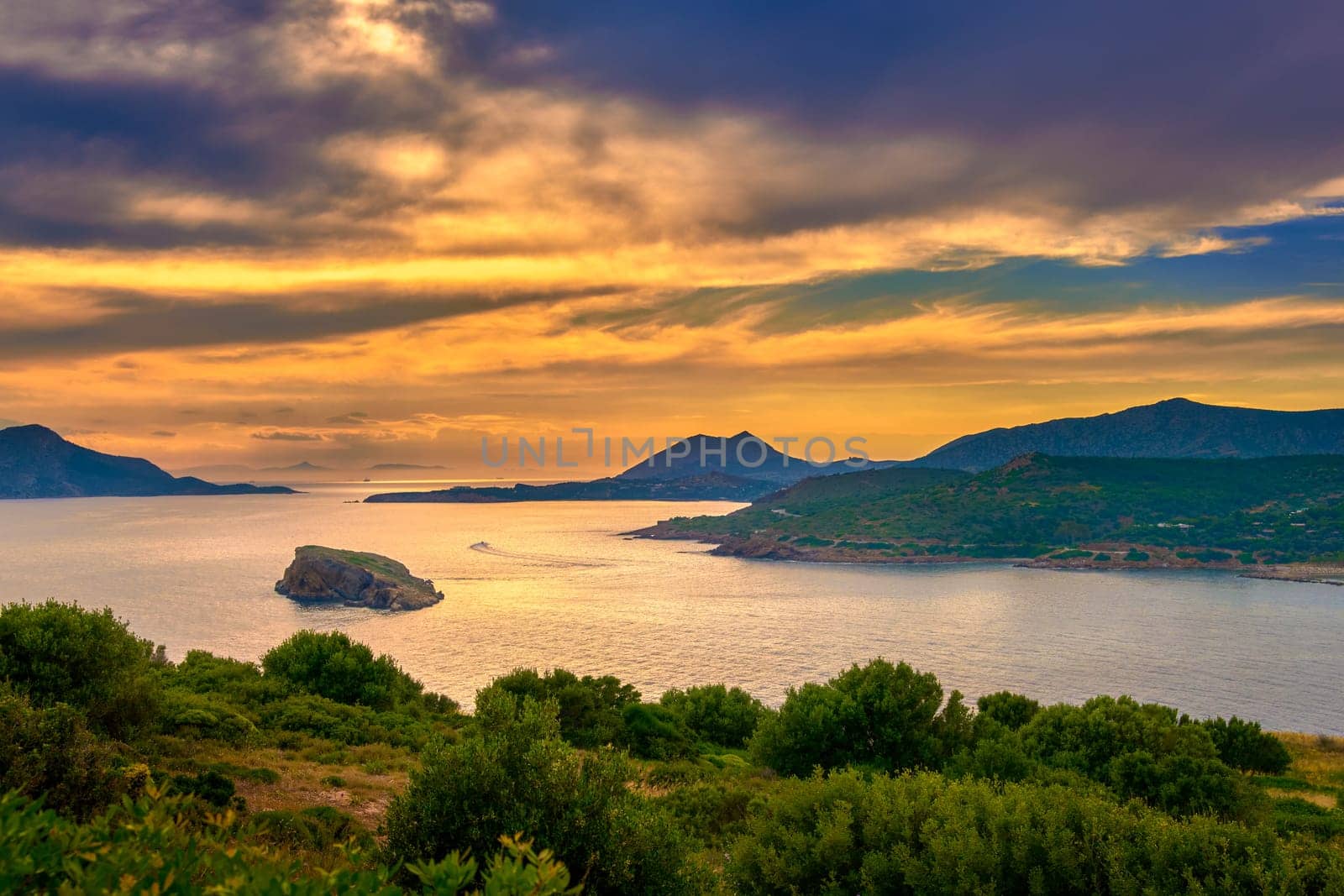Sunset on Mediterranean sea coast, summer evening at ancient Temple of Poseidon, Sounio, Greece. Tranquil coastal landscape with clear blue waters.
